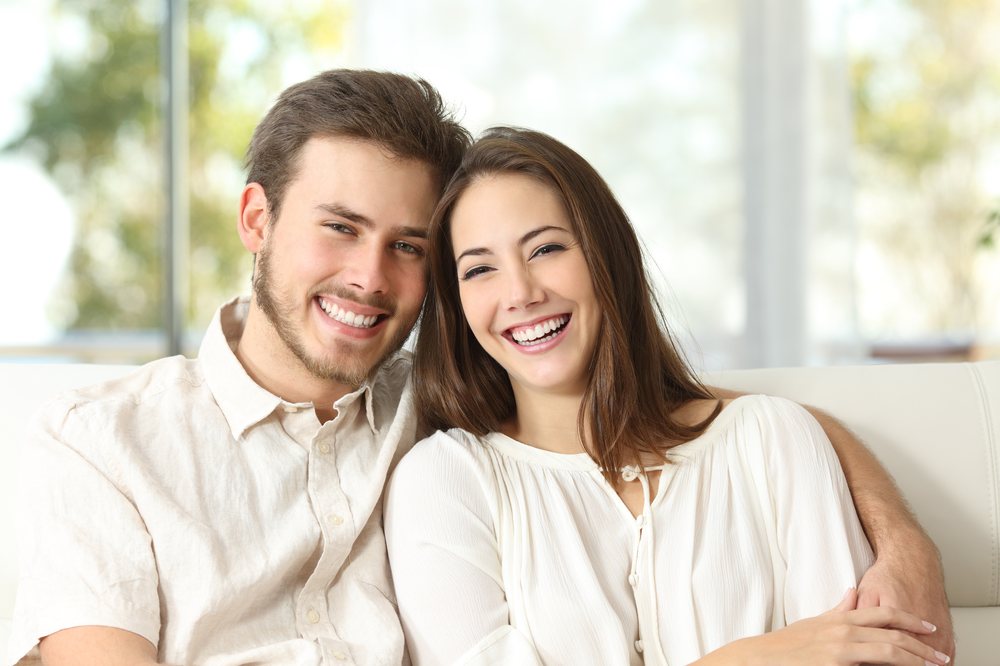 Happy couple smiling with confidence after their smile makeover
