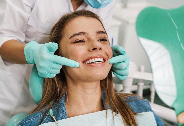 Cosmetic dentist showing a patient her new veneers smile in Southfield, MI